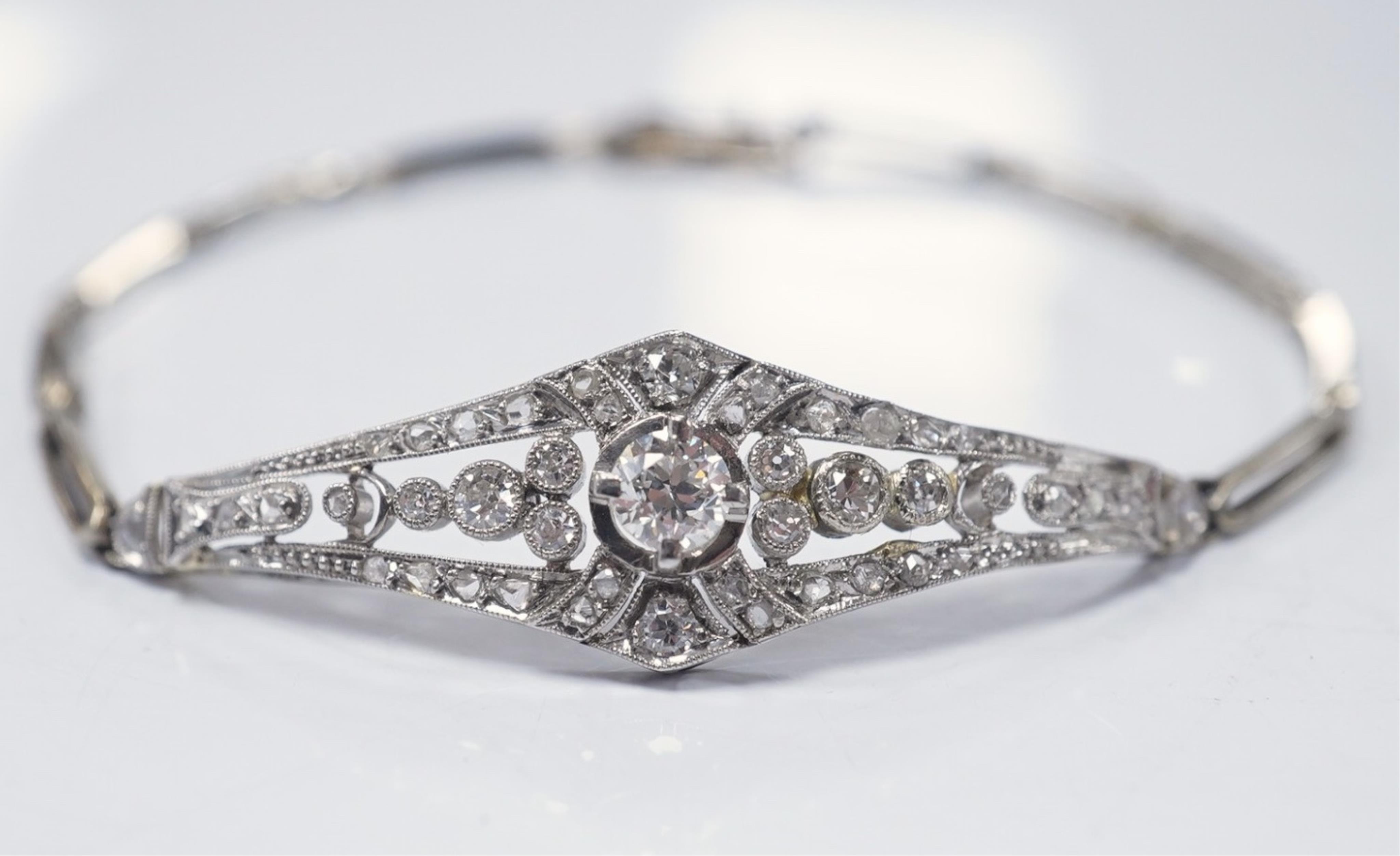 An early 20th century pierced gold, platinum and diamond set bracelet, the central motif set with round, eight and rose cut stones, 18cm, gross weight 8.9 grams. Condition - fair to good